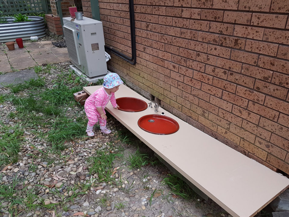 De oude lavabo van de keuken dient nu als modderkeuken. Een paar tweehandse potjes erbij en ze kan naar hartelust met modder bakken.